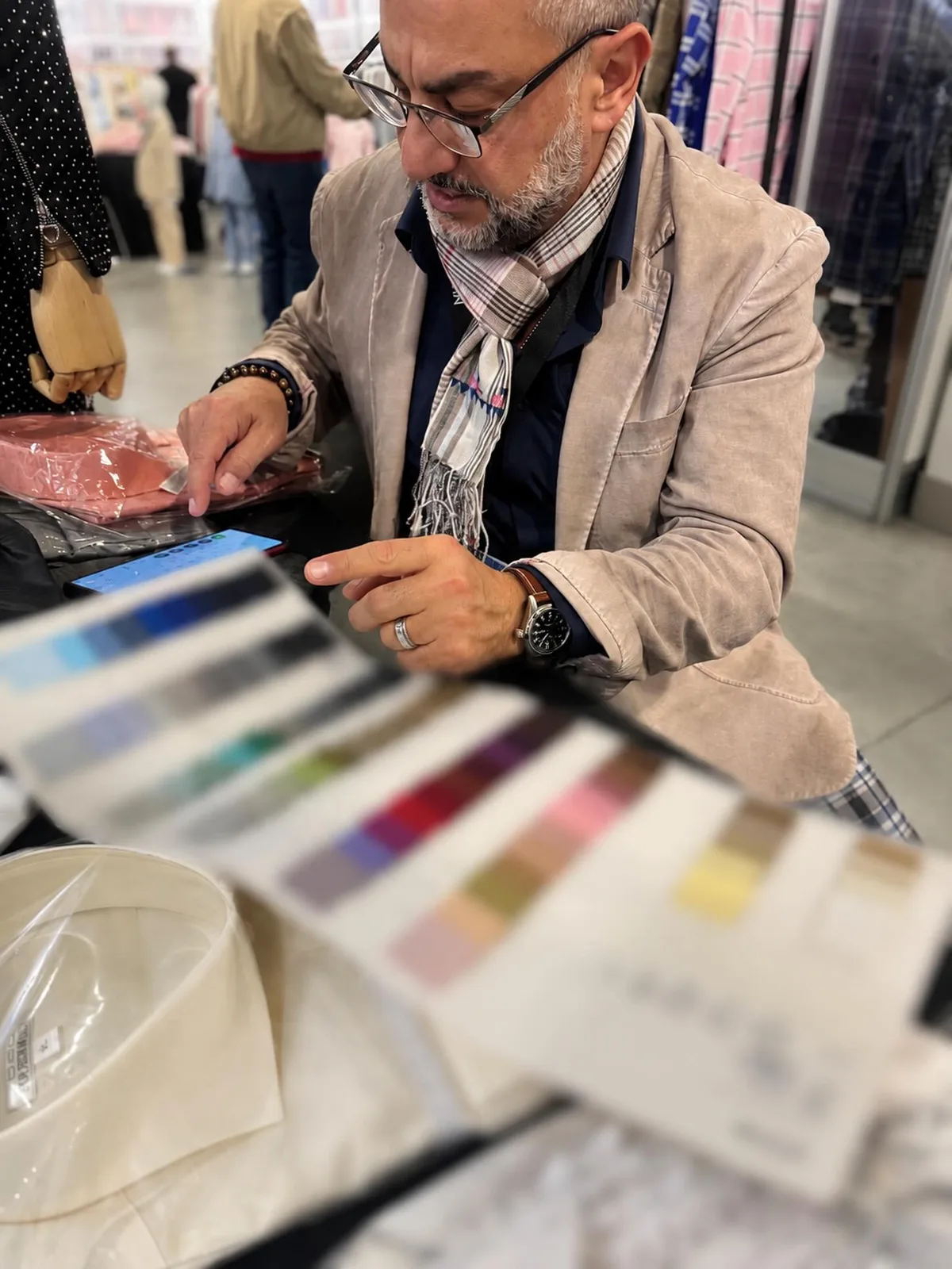 Hombre con traje gris y corbata burdeos en evento interior