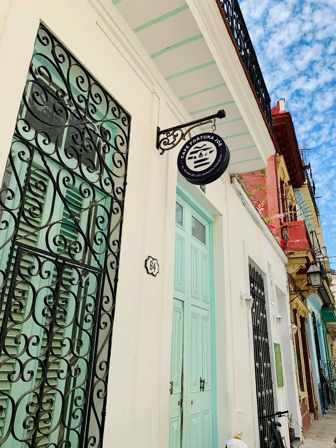 Fachada colonial con puerta verde y herrería ornamental Fortuna Joe