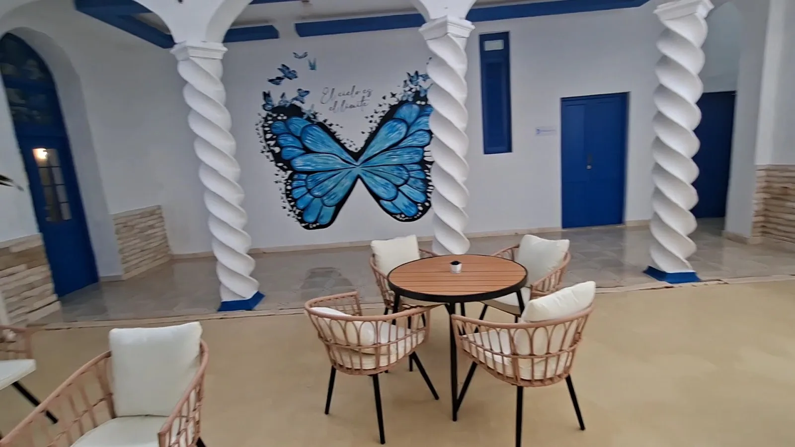 Rincón del salón en calma con textiles claros y flores frescas