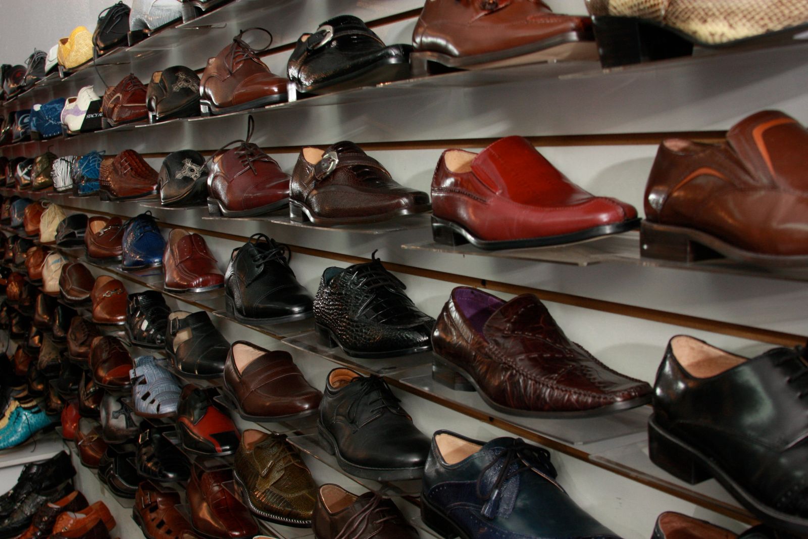 Zapatos de vestir de cuero junto a mocasines sobre fondo neutro